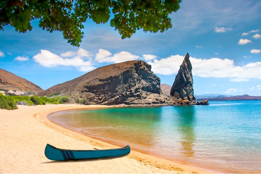 A small canoe resting on a sandy shore with a majestic mountain as the backdrop.