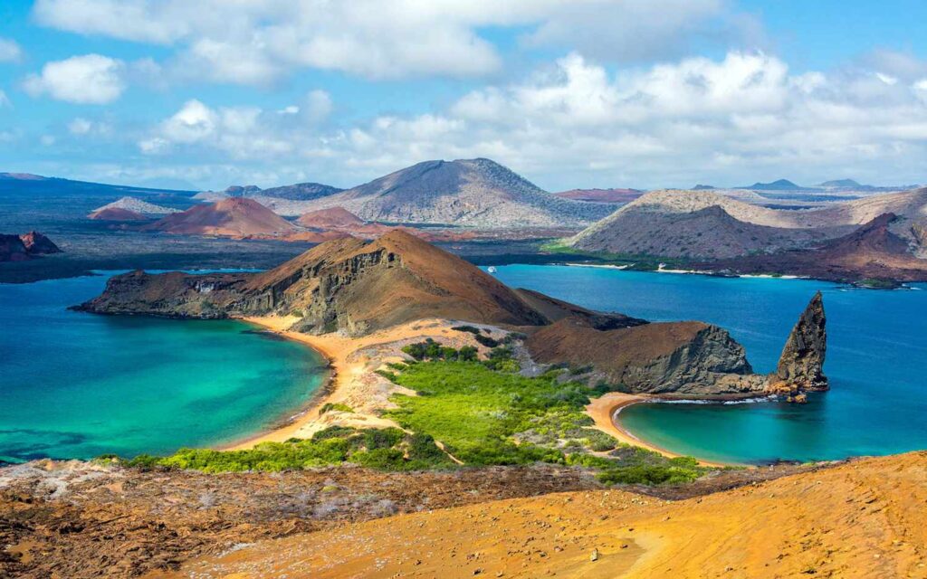 A breathtaking view of the Galapagos Islands, a volcanic archipelago located in the Pacific Ocean, known for its unique wildlife and diverse ecosystems. The image captures the pristine beauty of the islands, featuring crystal clear waters, sandy beaches, and lush green vegetation, surrounded by an endless horizon.