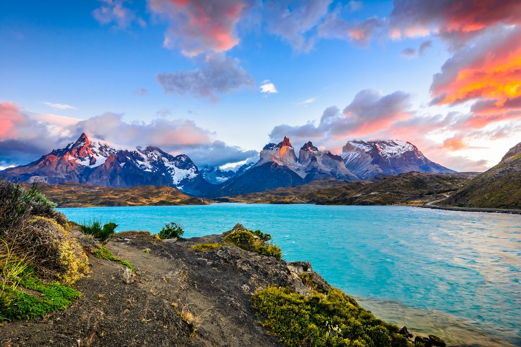 A mesmerizing image of the Torres del Paine mountain range towering over the turquoise waters of Pehoe Lake in Southern Patagonia, Chile.