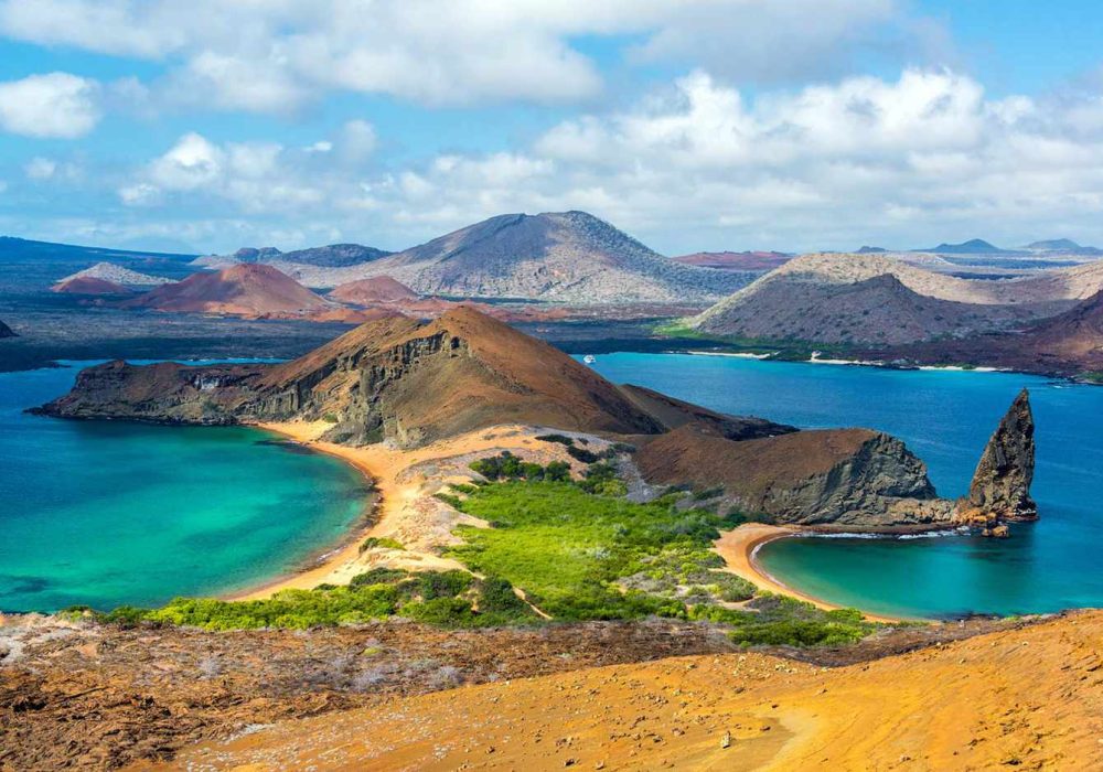 A breathtaking view of the Galapagos Islands, a volcanic archipelago located in the Pacific Ocean, known for its unique wildlife and diverse ecosystems. The image captures the pristine beauty of the islands, featuring crystal clear waters, sandy beaches, and lush green vegetation, surrounded by an endless horizon.